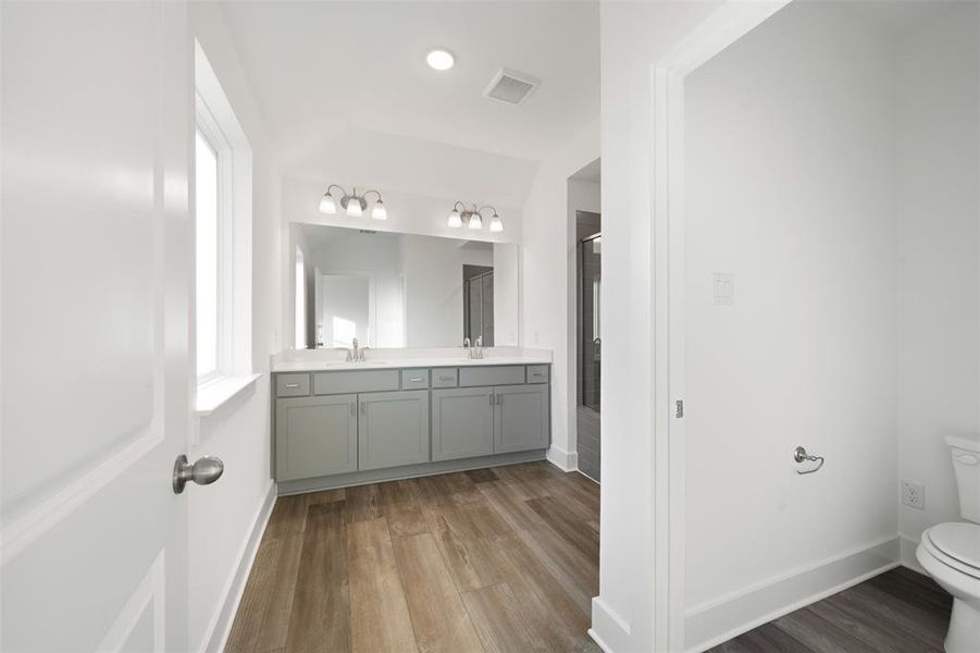 Bathroom with toilet, vanity, and hardwood / wood-style flooring