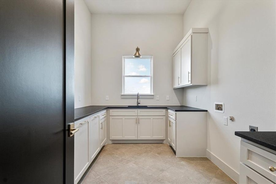 Kitchen featuring freestanding refrigerator, dark countertops, and white cabinets