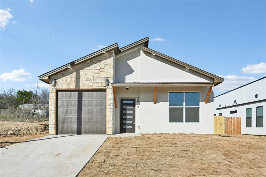 Front Contemporary house featuring a garage and a front lawn