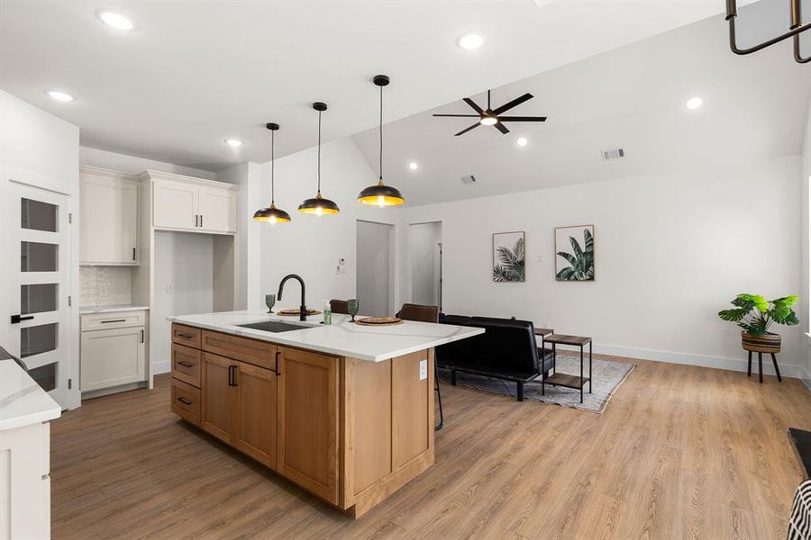 Kitchen with light countertops, a sink, visible vents, and light wood finished floors