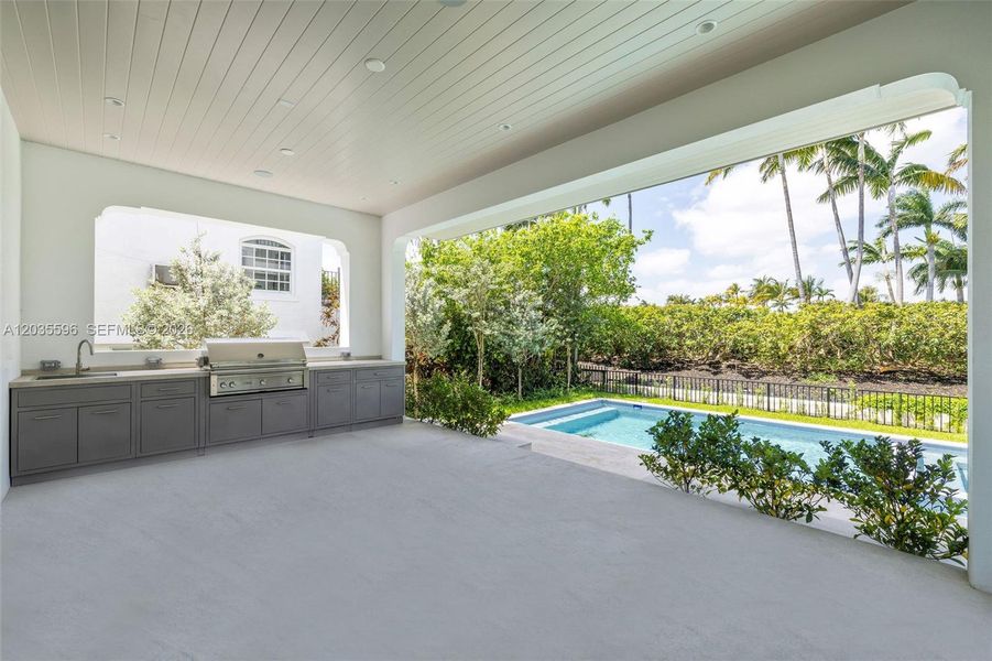 Outside living room with full kitchen overlooks pool Outside living room with full kitchen overlooks pool