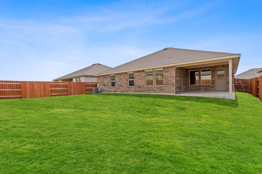 Rear view of house featuring a fenced backyard, brick siding, a patio area, and a shingled roof Rear view of house featuring a fenced backyard, brick siding, a patio area, and a shingled roof