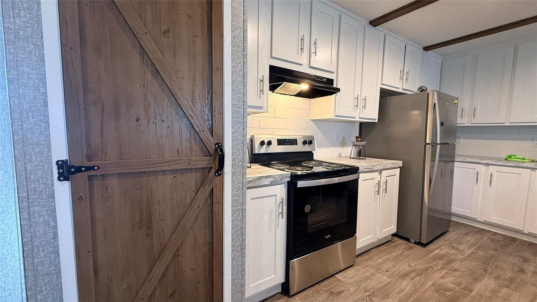 A well-appointed kitchen features stainless steel appliances and abundant white cabinetry, ready for culinary endeavors. A well-appointed kitchen features stainless steel appliances and abundant white cabinetry, ready for culinary endeavors.
