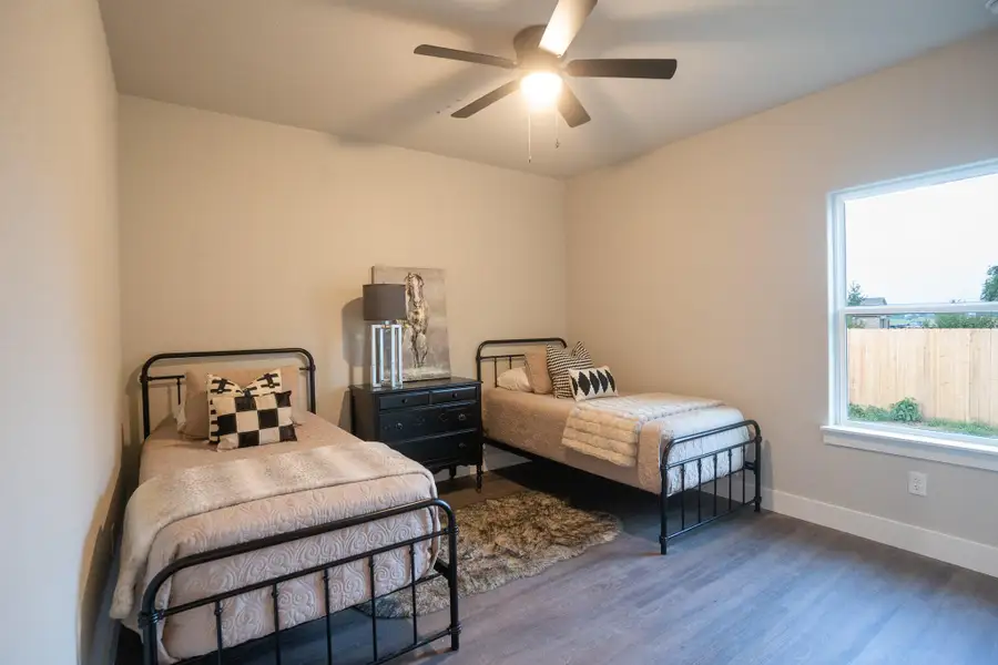 Bedroom featuring wood finished floors, baseboards, and a ceiling fan Bedroom featuring wood finished floors, baseboards, and a ceiling fan