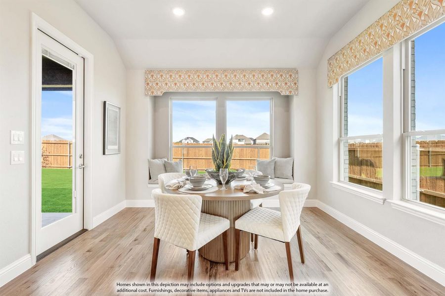 Bright breakfast nook with round dining table, window seat, hardwood floors, and backyard door access. Bright breakfast nook with round dining table, window seat, hardwood floors, and backyard door access.