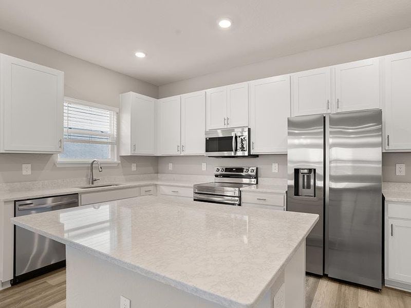 Your sunny kitchen includes an island, pantry, and beautiful finishes - Brynn bungalow by Highland Homes