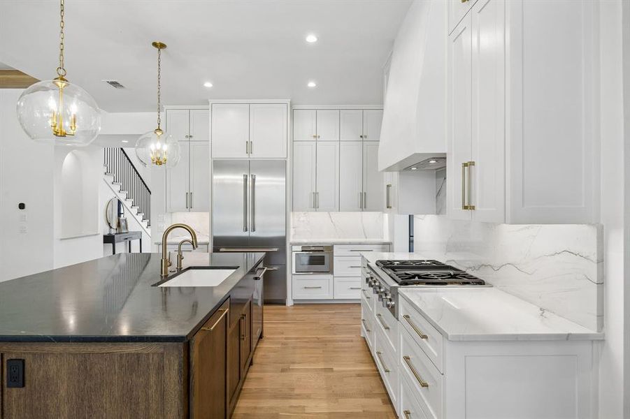 Kitchen features a farmhouse-style sink, a defining element of the space, alongside one of the two dishwashers.