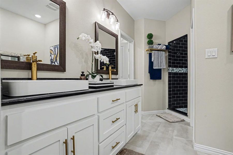 Full bathroom with vanity, a stall shower, and light tile patterned floors