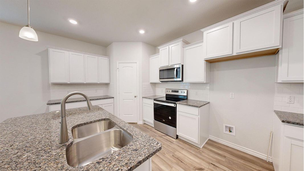 Kitchen featuring an island with a dual stainless steel sink and gooseneck faucet Kitchen featuring an island with a dual stainless steel sink and gooseneck faucet