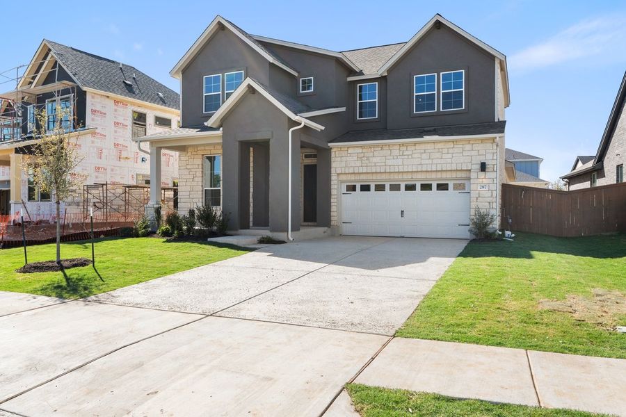 Front exterior of a new home in Persimmon, Buda, TX, highlighting curb appeal (Image 2). Front exterior of a new home in Persimmon, Buda, TX, highlighting curb appeal (Image 2).