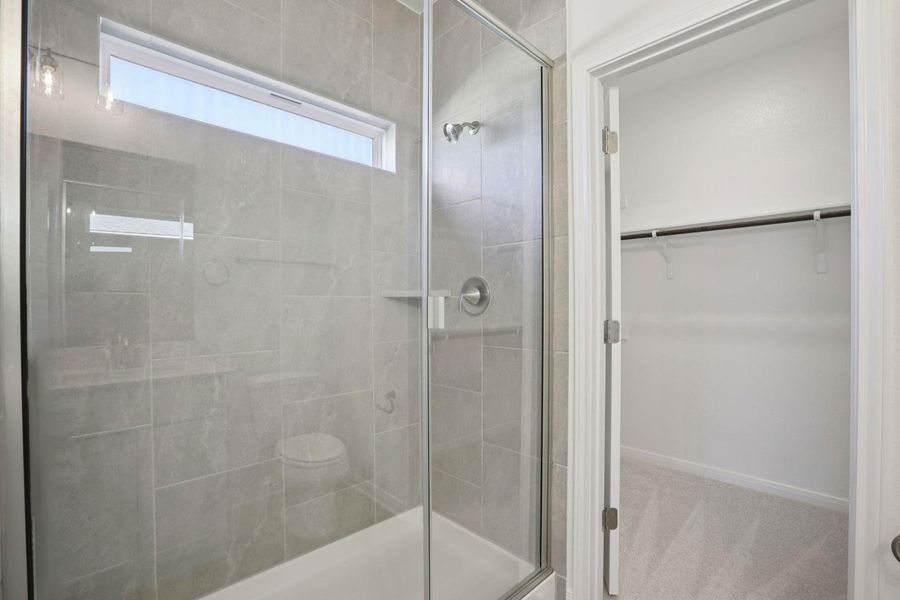 Bathroom with a spacious closet and a shower stall