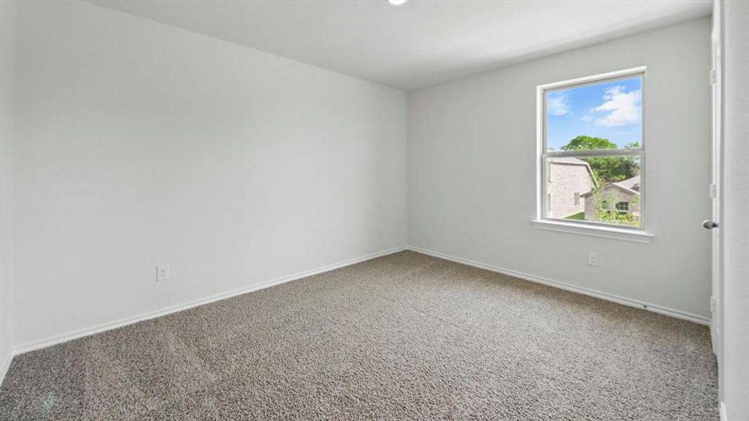 Carpeted empty room featuring baseboards