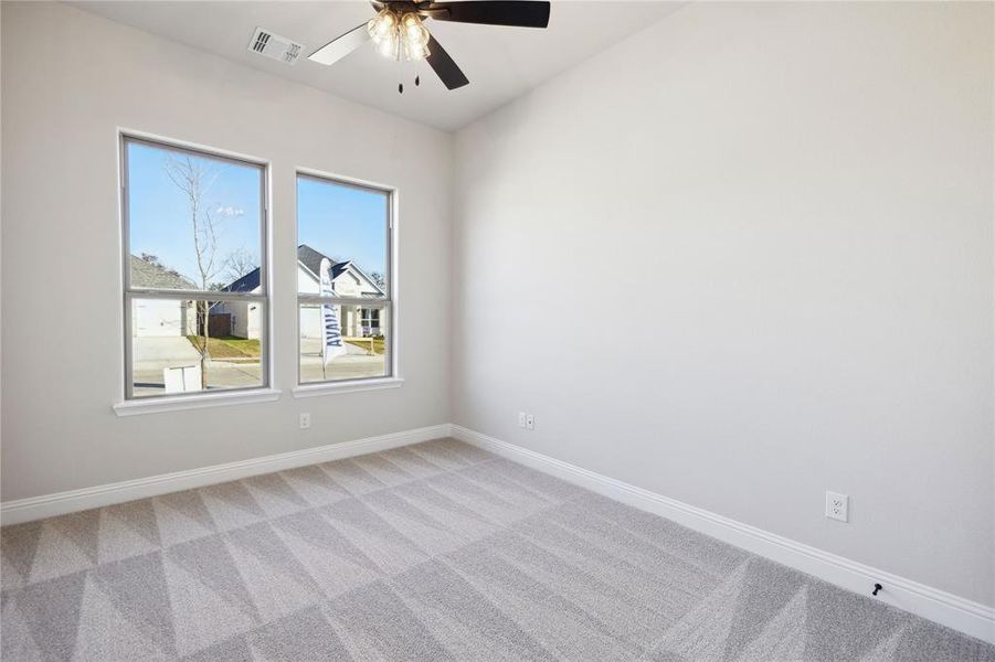 Carpeted empty room featuring ceiling fan