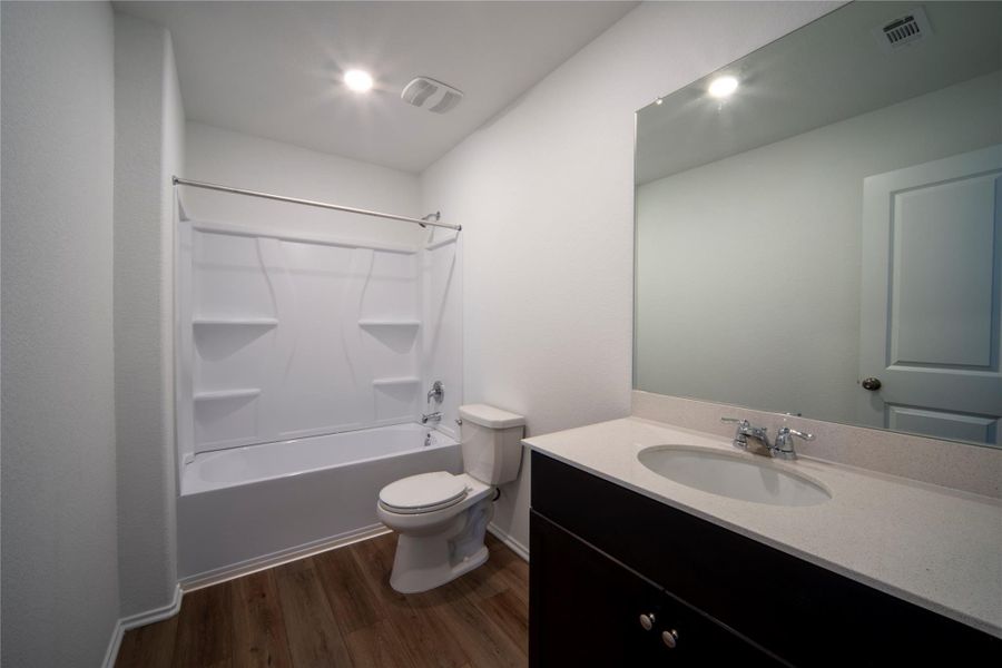 Full bath featuring vanity,  shower combination, and dark wood-style flooring