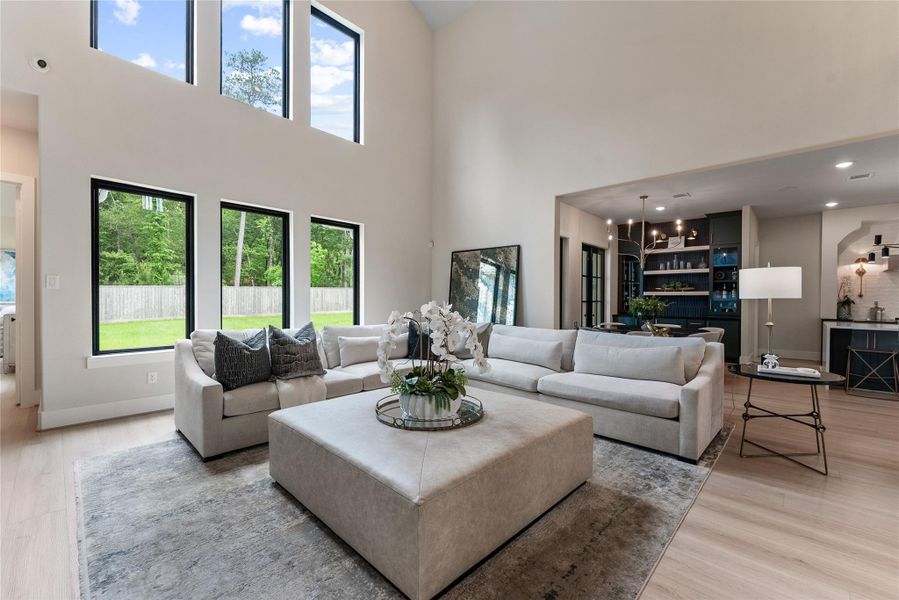 The open family room connects beautifully to the kitchen and casual dining spaces. Large windows frame the private lot, giving the home a bright and connected feel throughout the day.