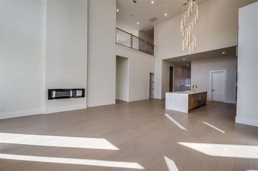 Unfurnished living room with hardwood / wood-style floors, a high ceiling, and heating unit
