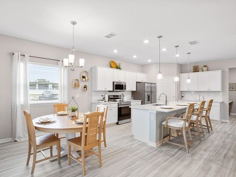 Meals are a delight in your new open kitchen with a counter-height island, walk-in pantry, and sunny dining cafe - Aubrey home plan by Highland Homes