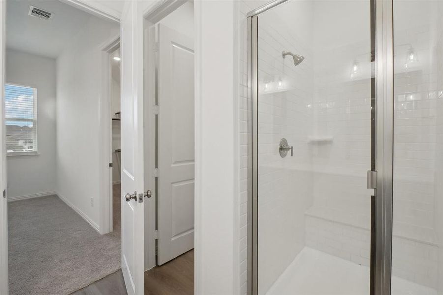 Bathroom with hardwood / wood-style floors and a shower with shower door