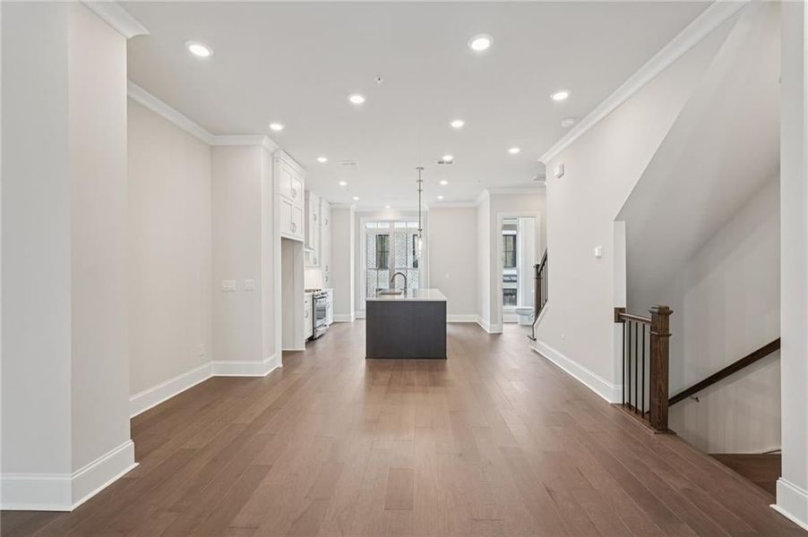 Unfurnished living room with recessed lighting, crown molding, and dark wood-style floors