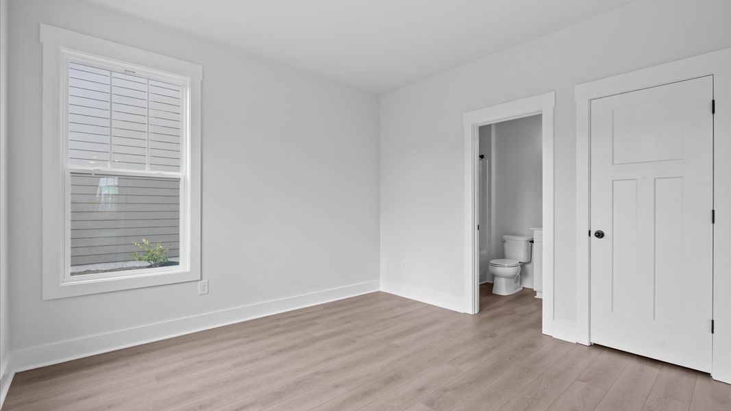 Thoughtfully designed secondary bedrooms featuring hardwood flooring and tasteful detail