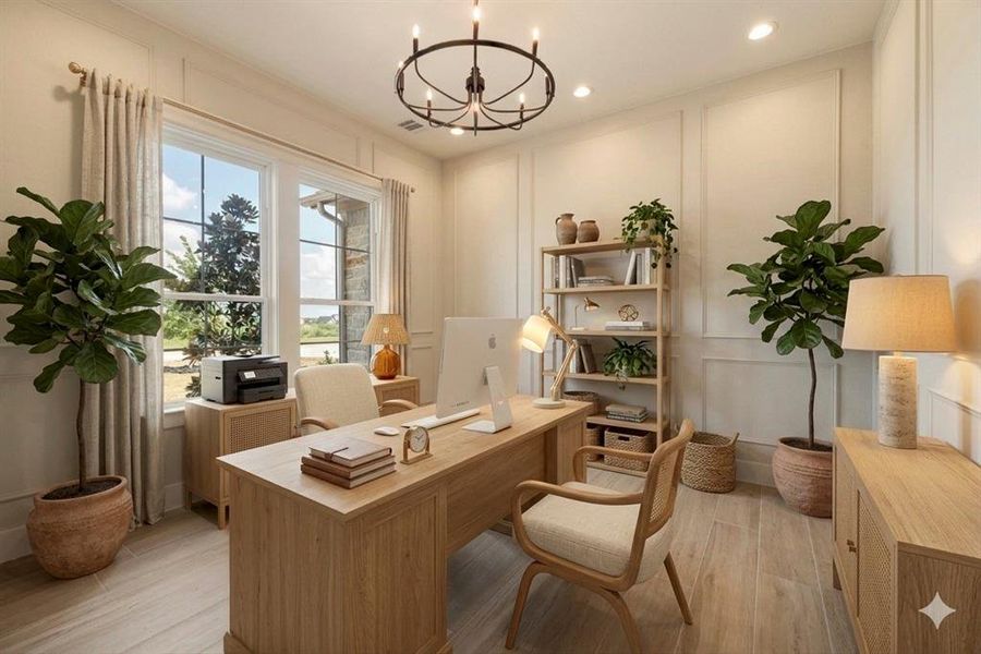 Office area with a decorative wall, light wood-style floors, and hanging lights