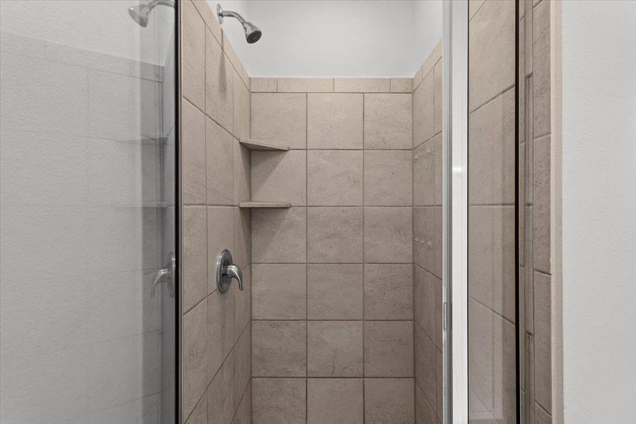 A well-appointed shower with neutral tile and practical corner shelving awaits. A well-appointed shower with neutral tile and practical corner shelving awaits.