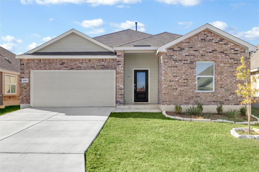 Ranch-style house with driveway, brick siding, a garage, and a front lawn