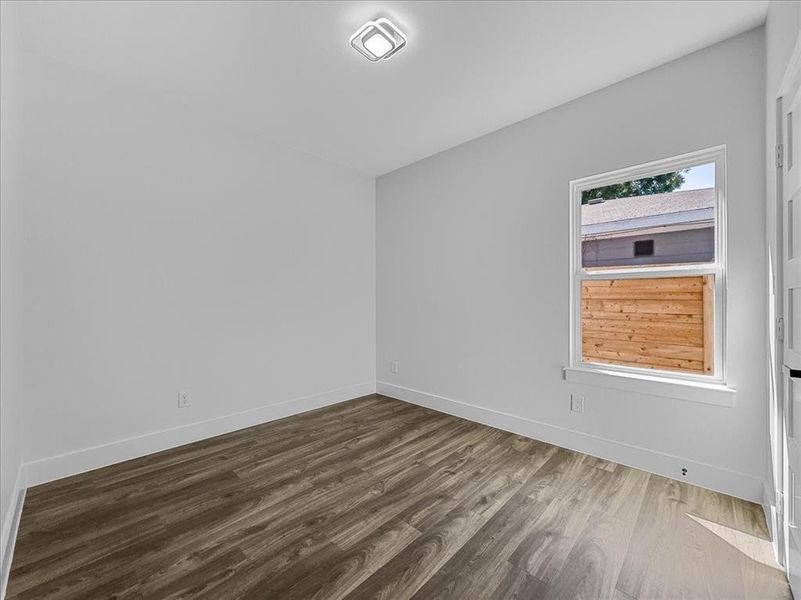 Unfurnished room featuring wood finished floors and baseboards Unfurnished room featuring wood finished floors and baseboards