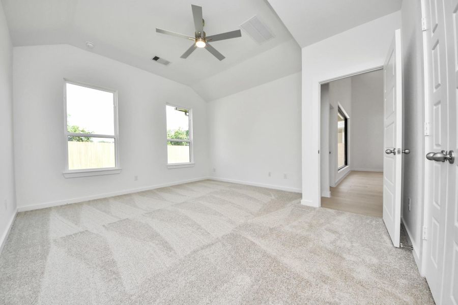 Come and unwind after a long day in this magnificent primary suite! This spacious room features plush carpet, warm paint, high ceilings and large windows with privacy blinds. Sample photo of completed home with similar floor plan. Actual colors and selections may vary.