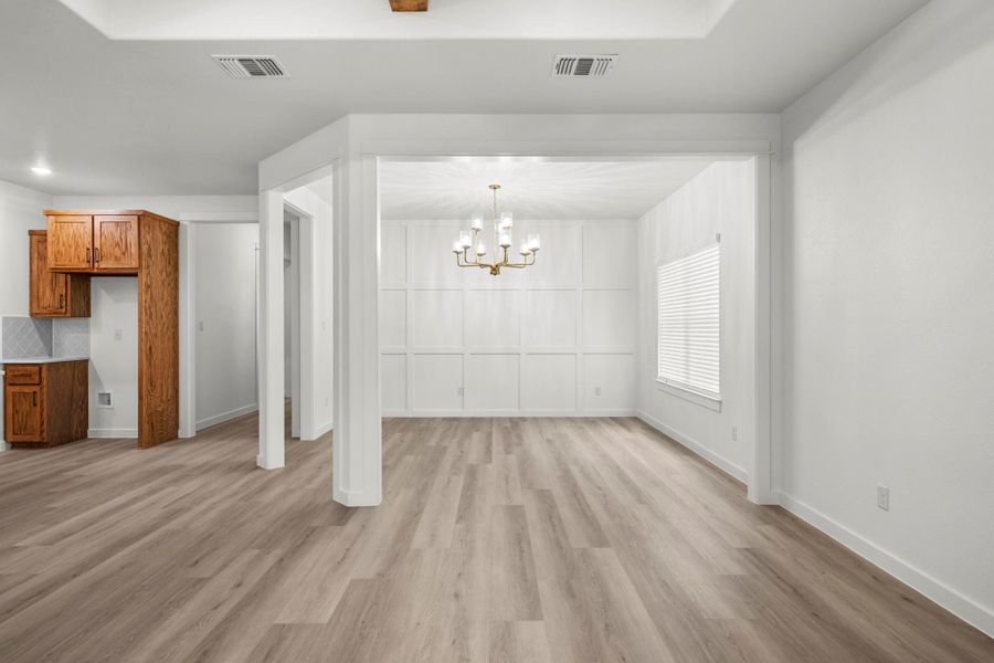 Board and batten accents highlight this inviting dining area with a modern chandelier and ample natural light. Board and batten accents highlight this inviting dining area with a modern chandelier and ample natural light.