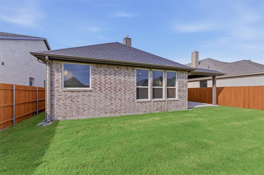 Expansive green lawn with a newly installed wood fence