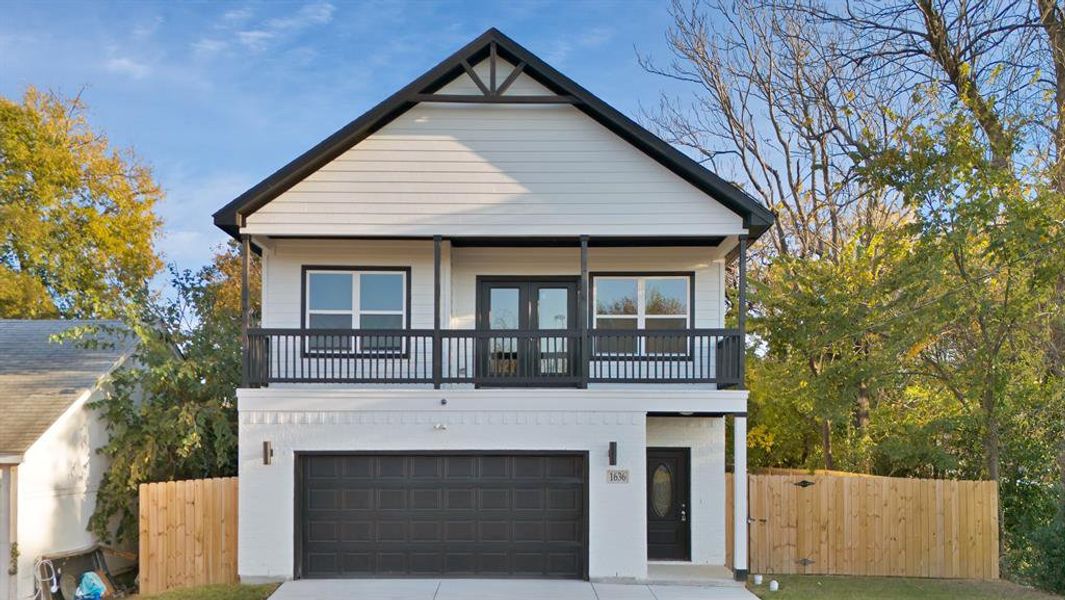 View of front of home featuring a balcony and a garage