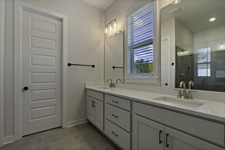 Dual vanity with undermount sinks, white cabinetry, and light-toned countertops