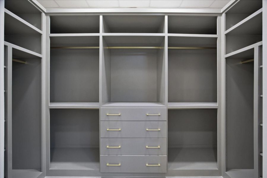 A fully customized walk-in closet offers tailored storage with clean lines and intentional organization.