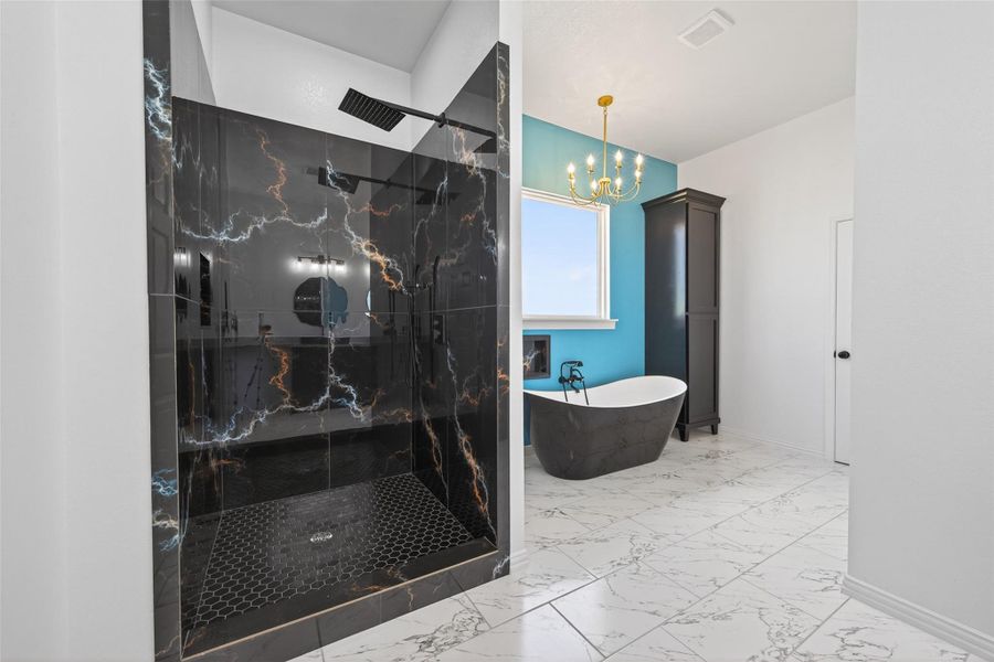 Elegant primary bathroom with dual sinks, custom cabinetry, a freestanding soaking tub, and walk-in shower.