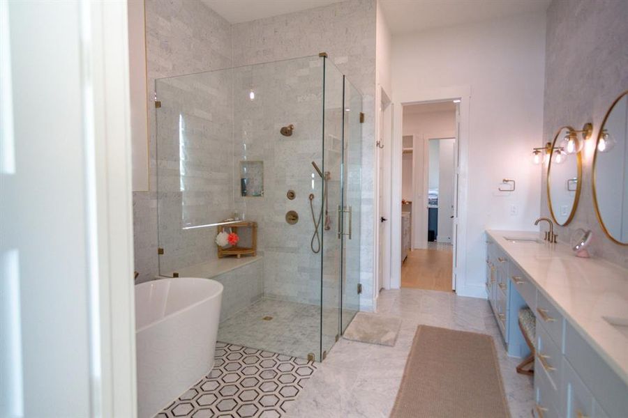 Bathroom with a soaking tub, a stall shower, double vanity, and light tile patterned floors Bathroom with a soaking tub, a stall shower, double vanity, and light tile patterned floors
