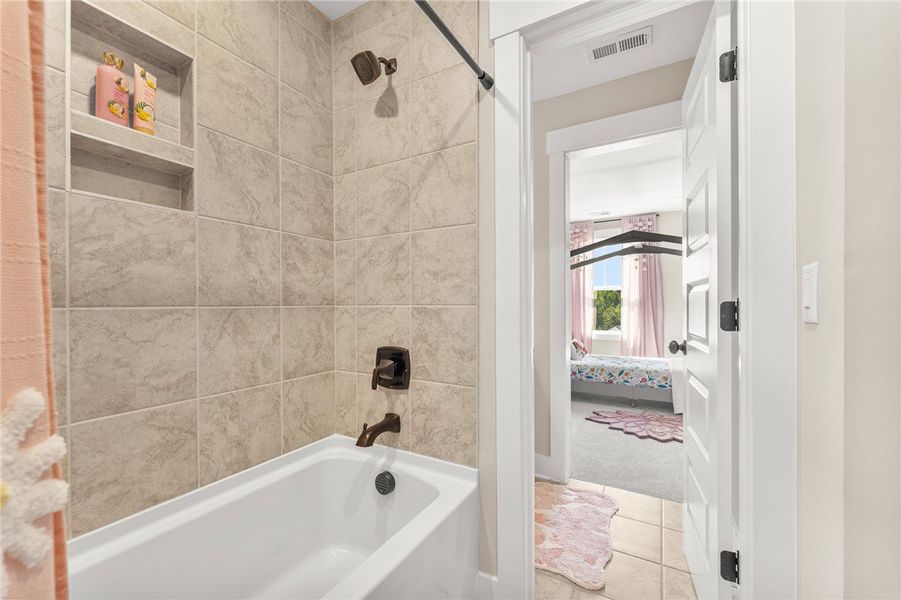 This clean bathroom features tiled walls and a fun