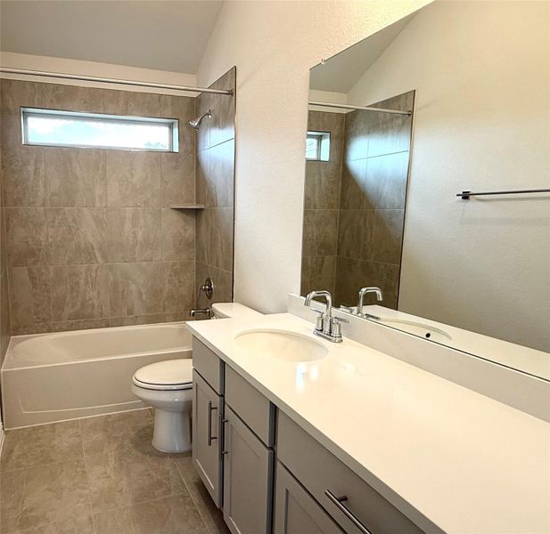 Full bathroom featuring vaulted ceiling, vanity, and bathing tub / shower combination Full bathroom featuring vaulted ceiling, vanity, and bathing tub / shower combination