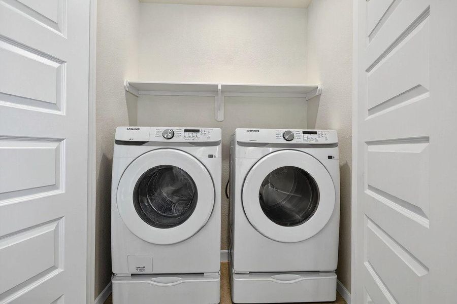 Conveniently located laundry with front-loading washer and dryer, built-in shelving, and space-saving double doors. Conveniently located laundry with front-loading washer and dryer, built-in shelving, and space-saving double doors.