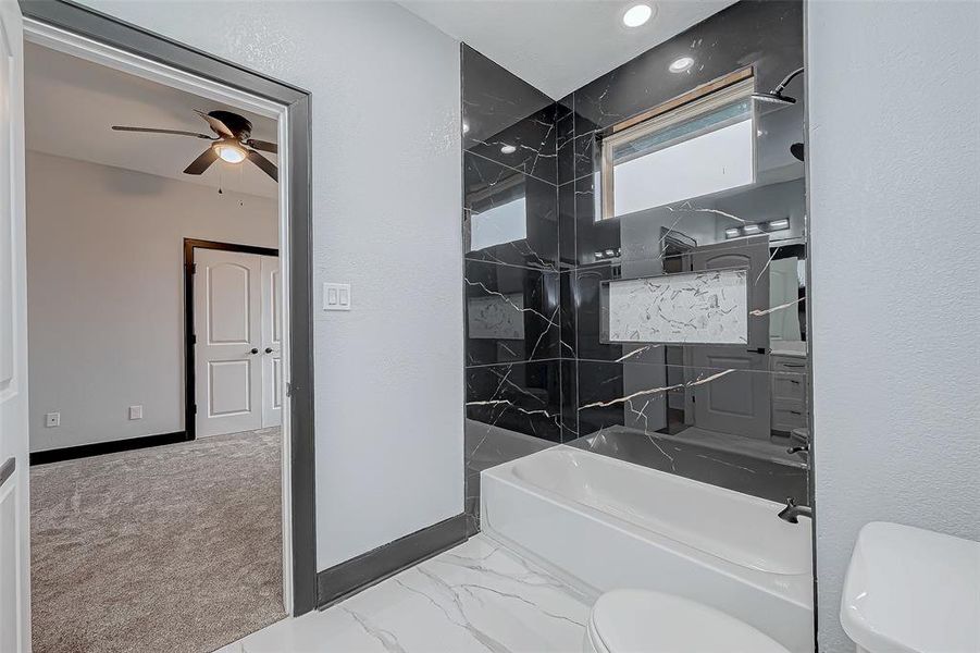 This bathroom, with its bathtub and shower combination, features beautiful finishes, two sinks, and serves two adjacent rooms.