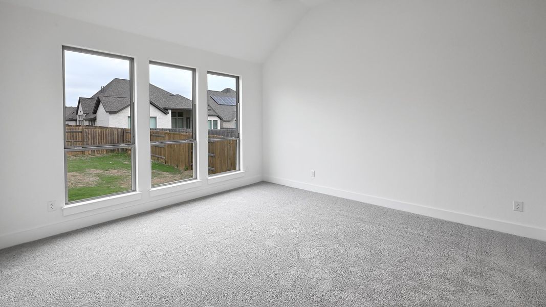 Empty room with baseboards, carpet flooring, and vaulted ceiling