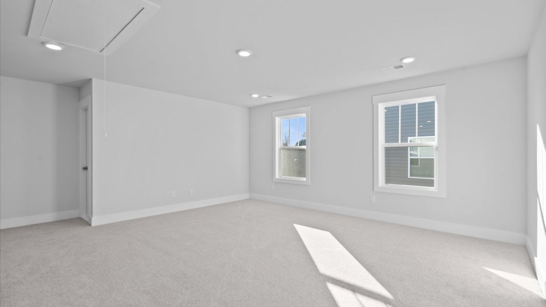 Elegant, carpeted game room that adds a superior layer of flexibility to the home’s design