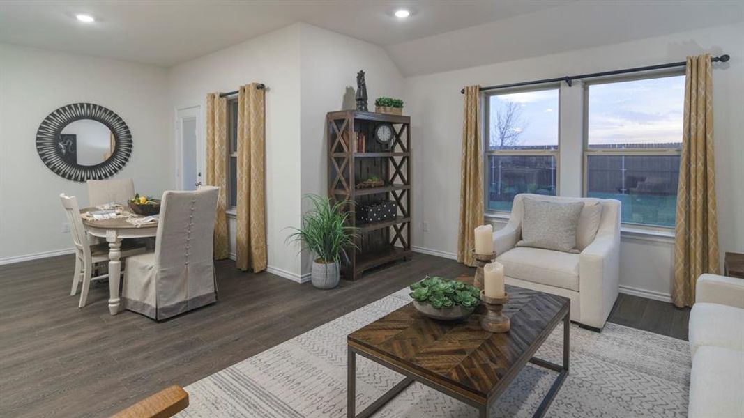 Living room with dark wood-style flooring, recessed lighting, and vaulted ceiling