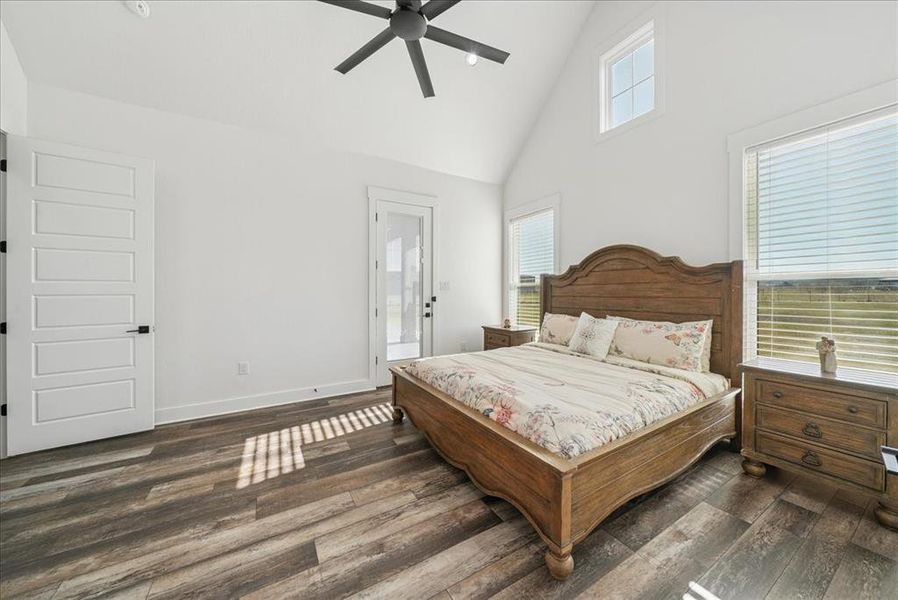 Bedroom featuring high vaulted ceiling, dark wood finished floors, access to exterior, and a ceiling fan