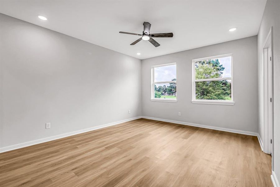 Primary bedroom is bright with windows overlooking the back yard green space.