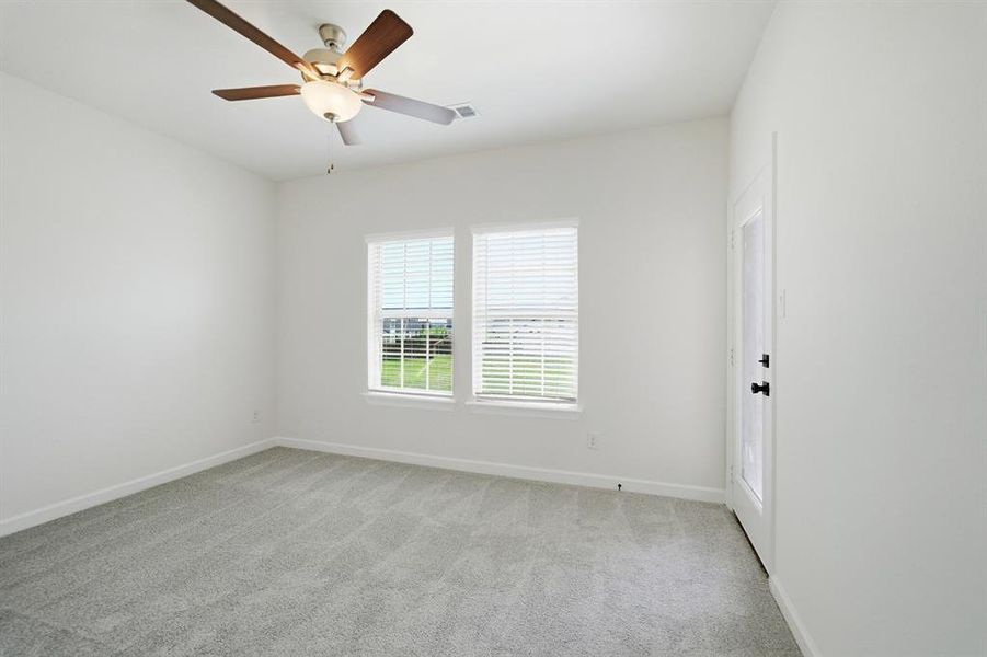 Room featuring light gray carpet flooring, white walls, and a ceiling fan with light fixture