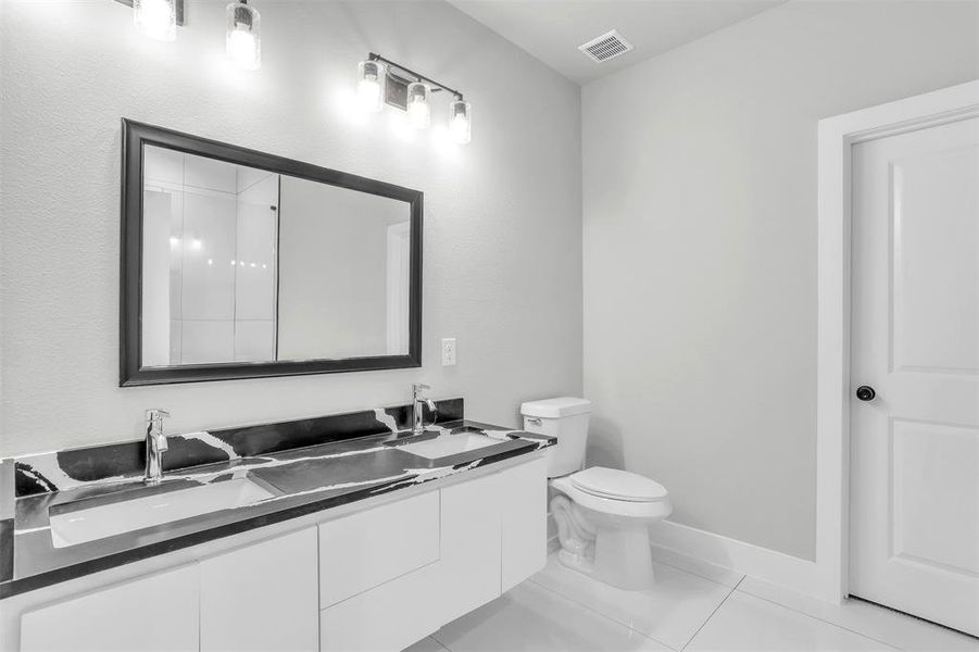 Bathroom featuring tile patterned flooring, vanity, and toilet