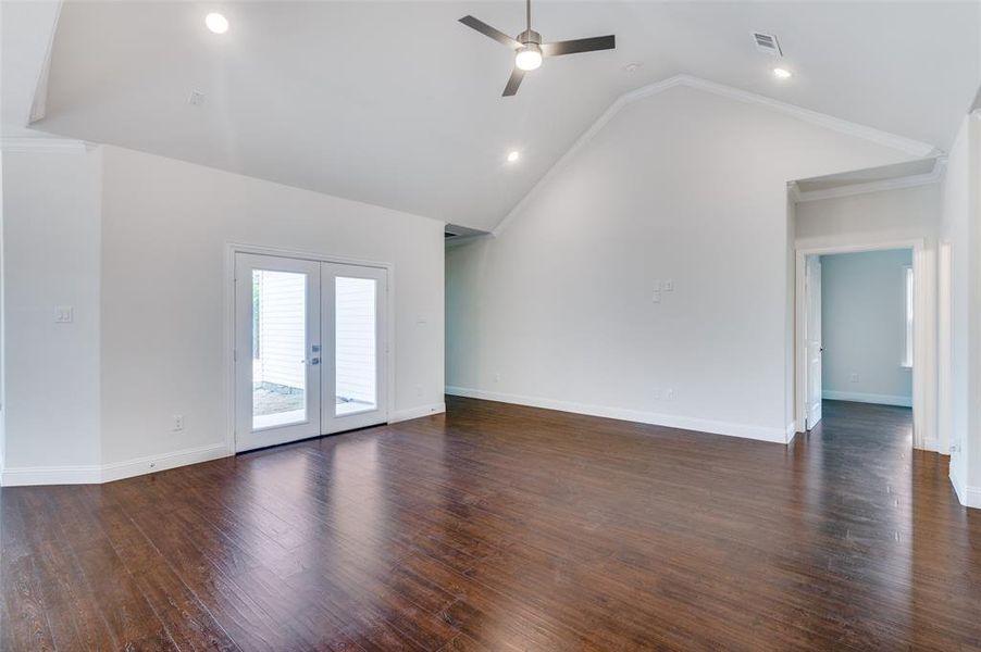 Unfurnished living room with wood-type flooring, french doors, and ceiling fan