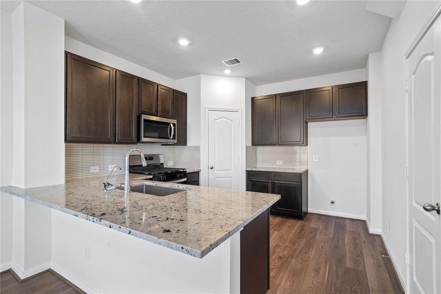 This kitchen is by far any chef’s dream! This spacious kitchen features high ceilings, stained wood cabinets, granite countertops, SS appliances, modern tile backsplash, recessed lighting, space for breakfast bar and a walk-in pantry all overlooking your huge family room.