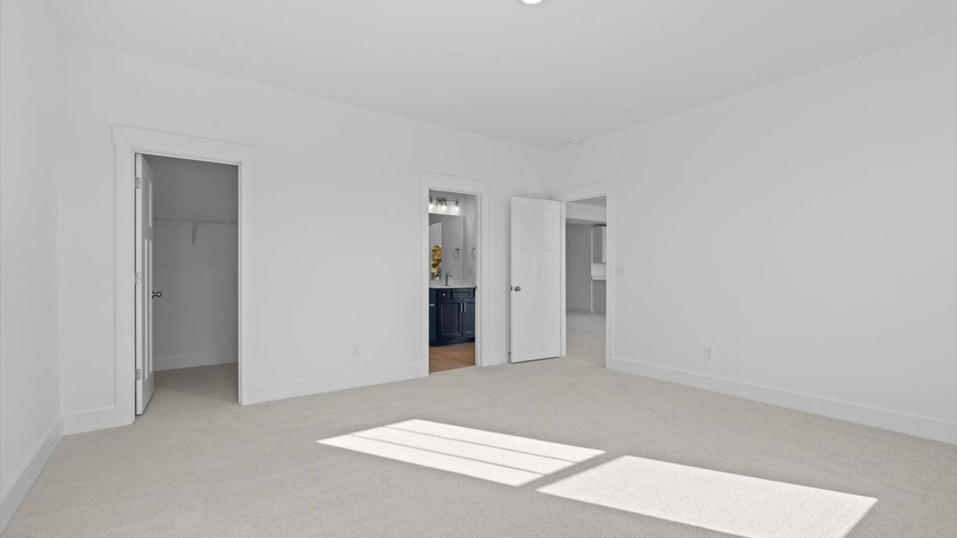 Highly functional bedroom with large windows, carpeted flooring, and tasteful finishes throughout